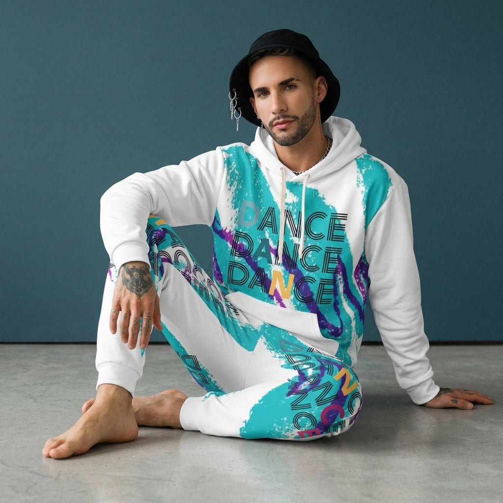 Close-up of male model with a beard, tattoos, layered earrings, wearing a white hoodie with colorful paint splatter and 'DANCE' text, posing with hand on head.