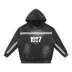Sudadera con capucha negra con diseño de graffiti, detalles de rayas blancas en las mangas, estilo casual y moderno para ropa deportiva y callejera.