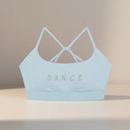 MONROE STORE light blue strappy criss-cross back sports bra with "D.A.N.C.E." graphic. Ideal for yoga and gym.