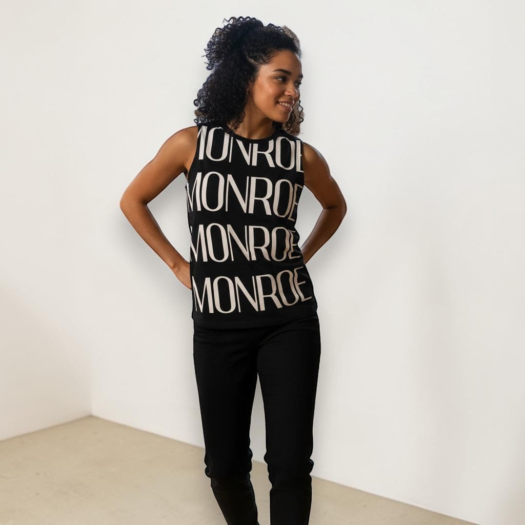 Modelo con camiseta de tirantes negra MONROE STORE de poliéster con estampado gráfico grande en blanco