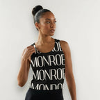 Modelo con camiseta de tirantes negra con estampado gráfico MONROE STORE, estilo casual y deportivo de poliéster.