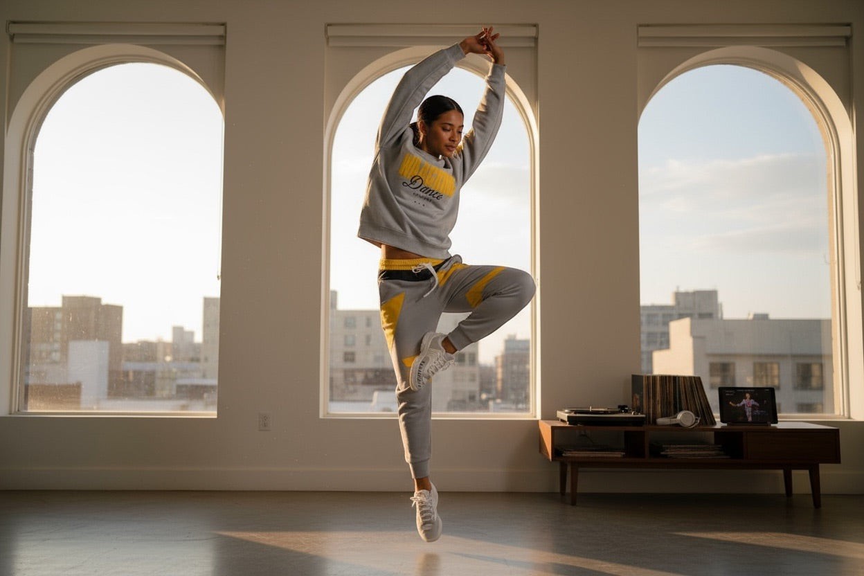 MONROE STORE grey cotton blend tracksuit with yellow accents. Woman in dance pose.