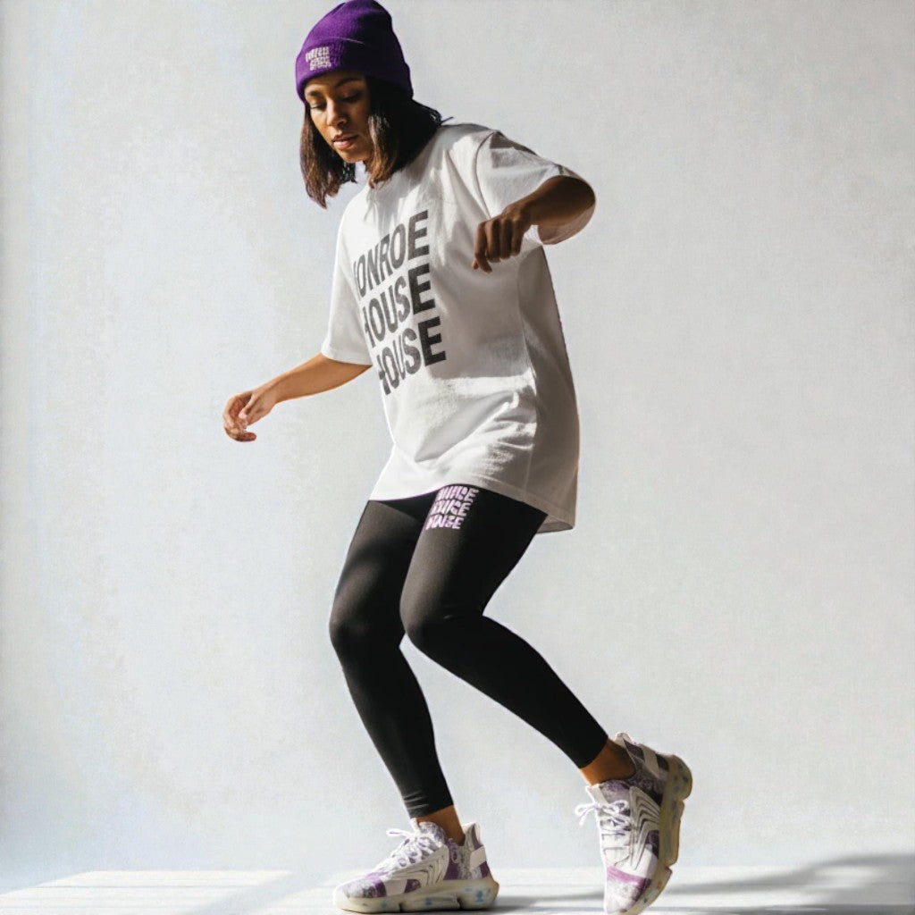 MONROE STORE mujer con gorro morado, camiseta blanca y mallas negras con estampado "MONROE HOUSE".
