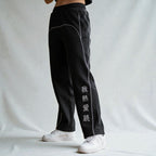 MONROE STORE pantalones de chándal negros de pierna recta con cordón, costuras blancas y texto en chino en la pierna.