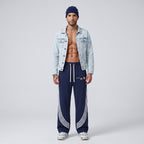 Modelo masculino con pantalones de chándal azul marino MONROE STORE con rayas curvas blancas y cordón ajustable