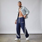 Modelo masculino con pantalones de chándal azul marino de MONROE STORE con rayas curvas blancas y cordón ajustable