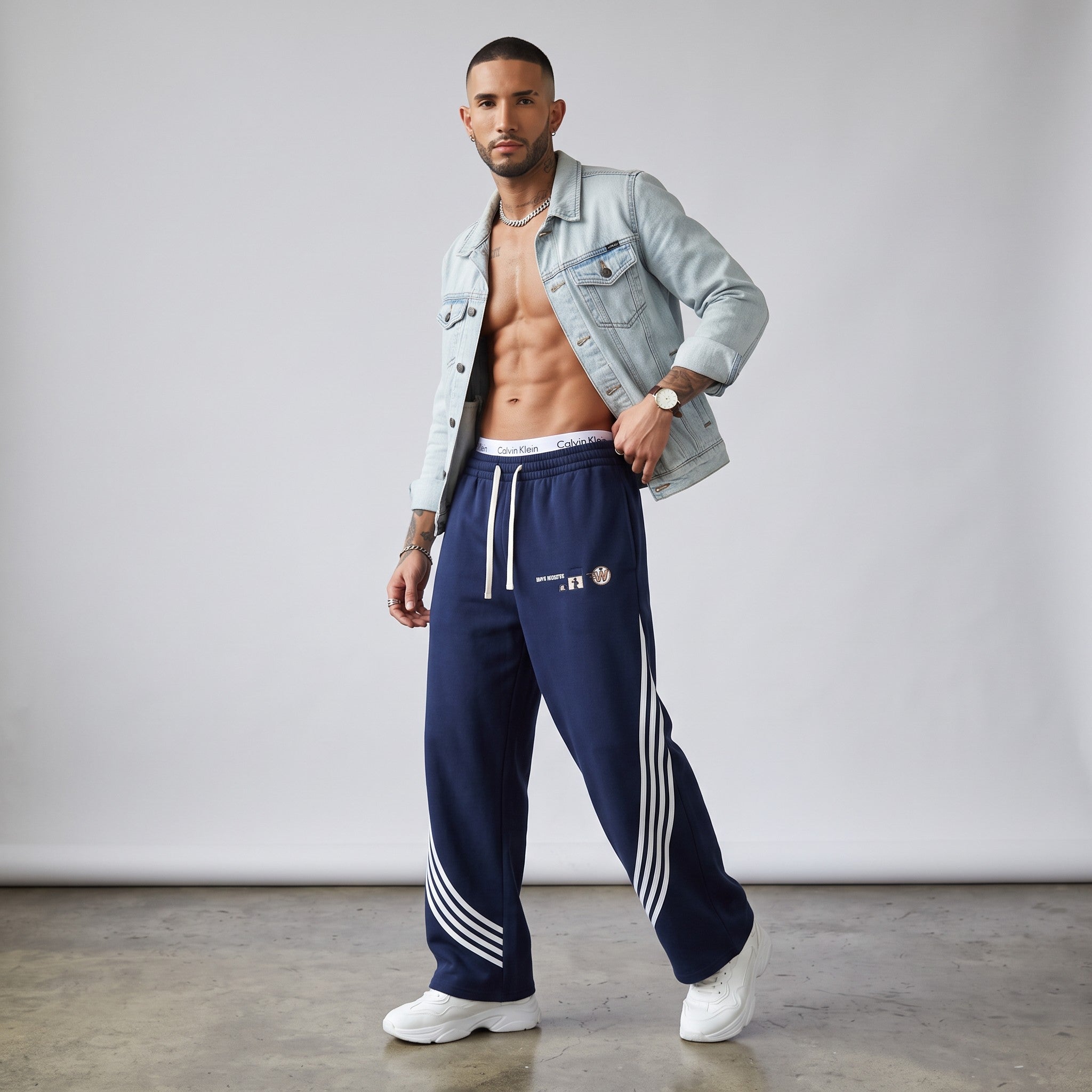 Modelo masculino con pantalones de chándal azul marino de MONROE STORE con rayas curvas blancas y cordón ajustable