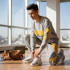 Joven con conjunto deportivo gris y amarillo MONROE STORE preparándose para clase de baile en estudio luminoso