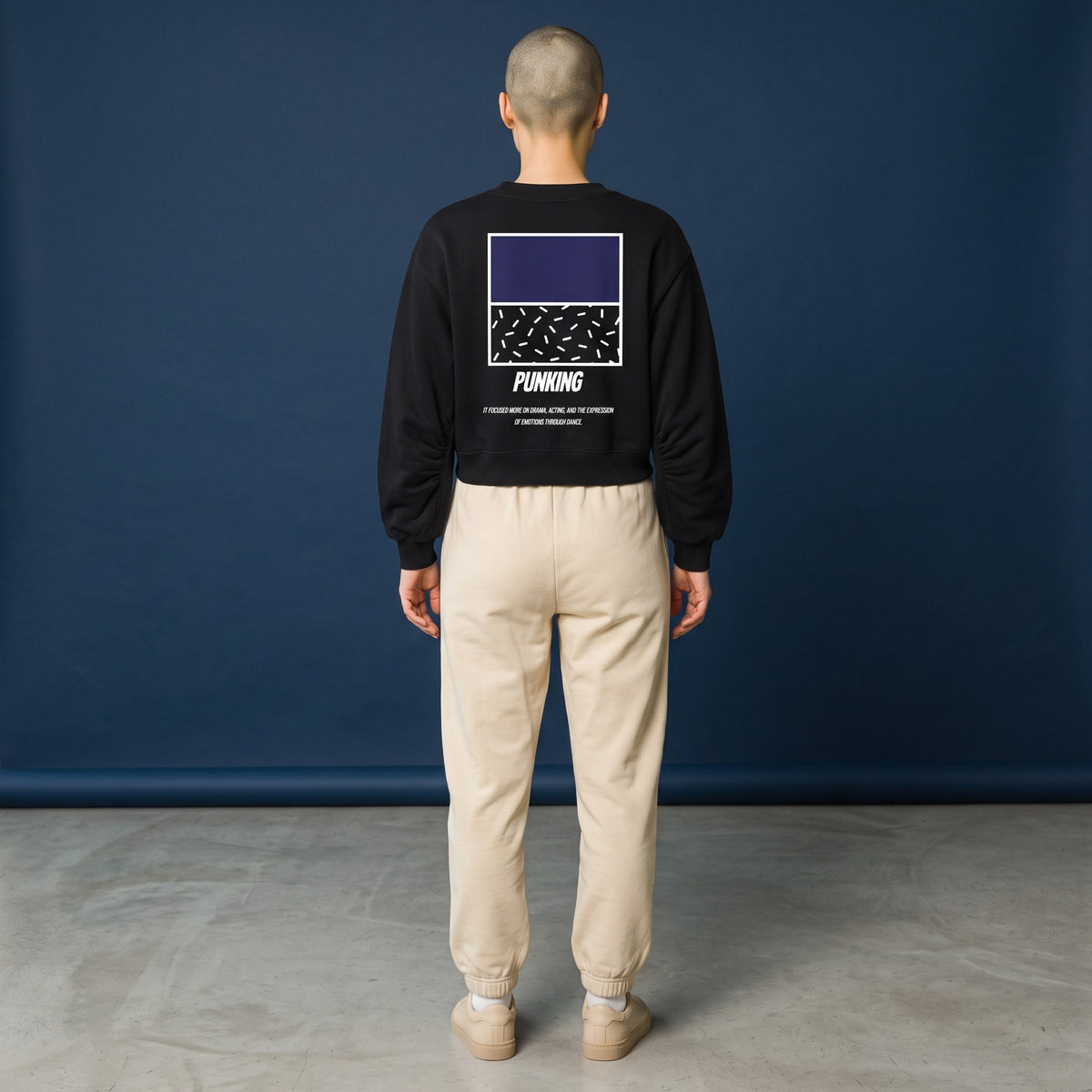 Sudadera corta negra MONROE STORE con cuello en V, manga larga y estampado gráfico en la espalda sobre fondo azul.