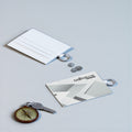 Monroe Store tarjetero blanco de piel sintética con anilla y ranuras para tarjetas, junto a una llave y monedas.